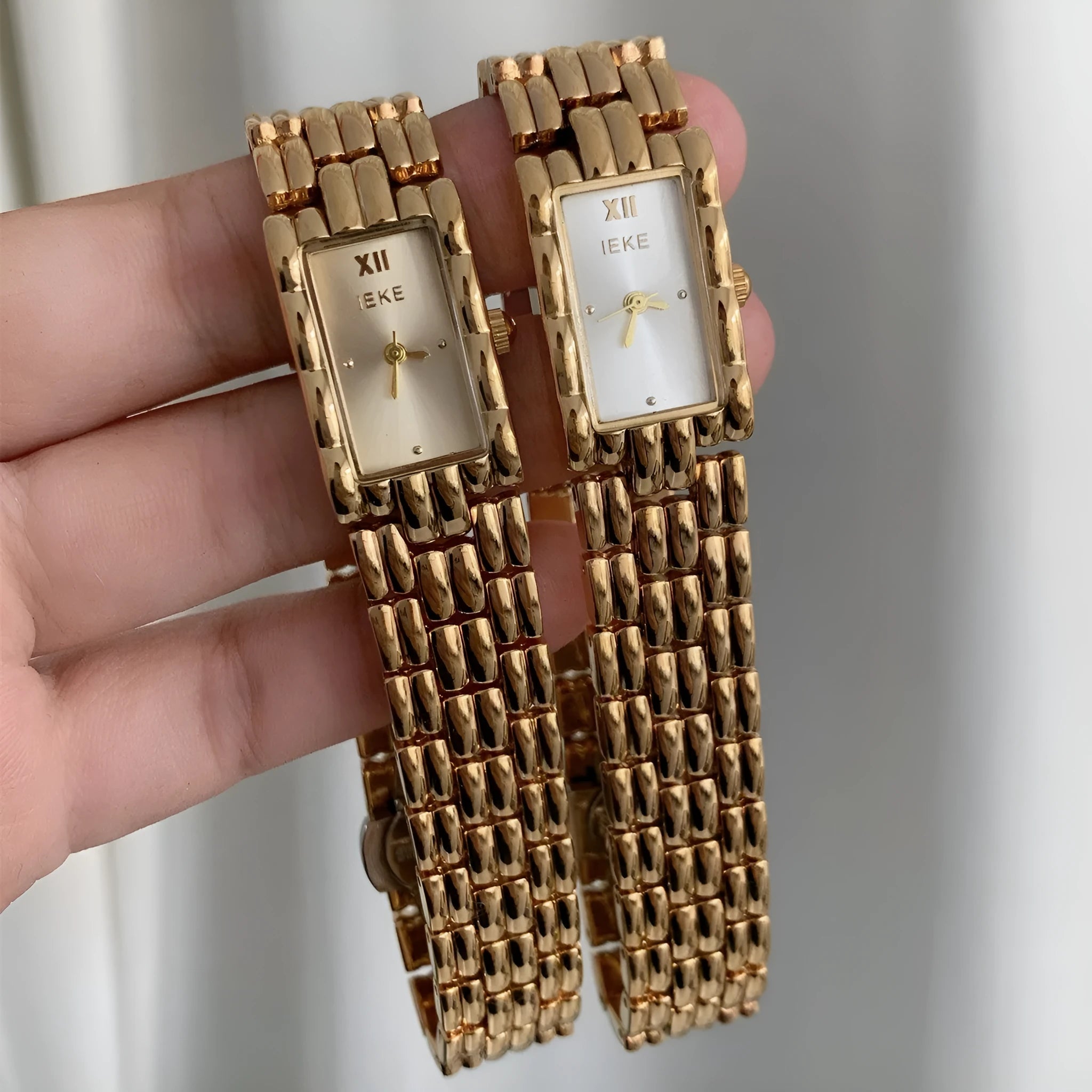 Women's silver and gold bracelet-style watch with a small 15mm dial and butterfly clasp.