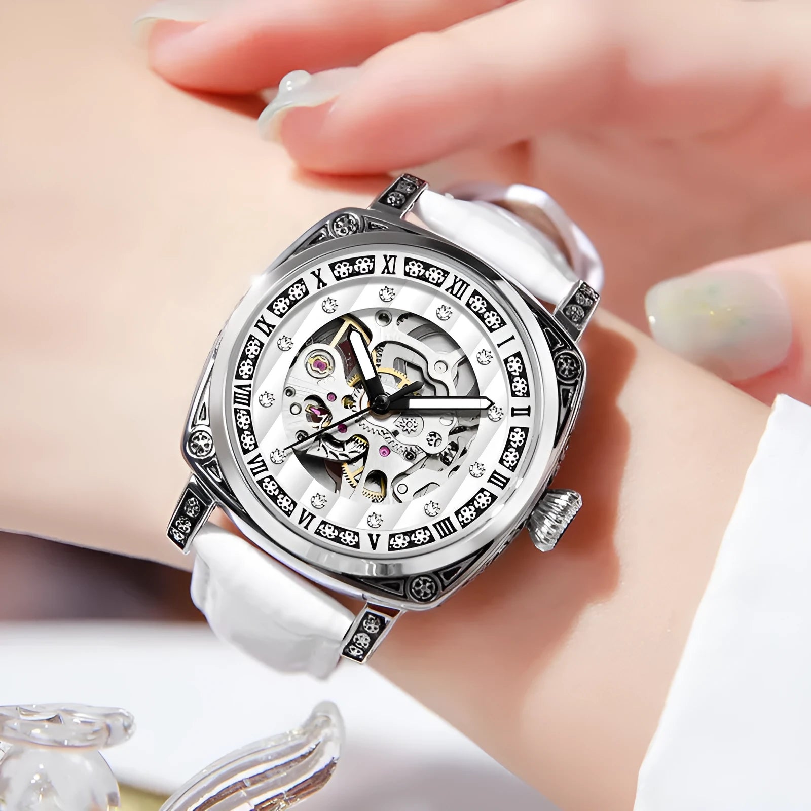 Mechanical watch with luminous hands and a black leather strap on a wrist.