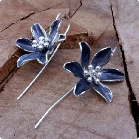 A pair of purple flower-shaped alloy earrings with a retro elegant design.
