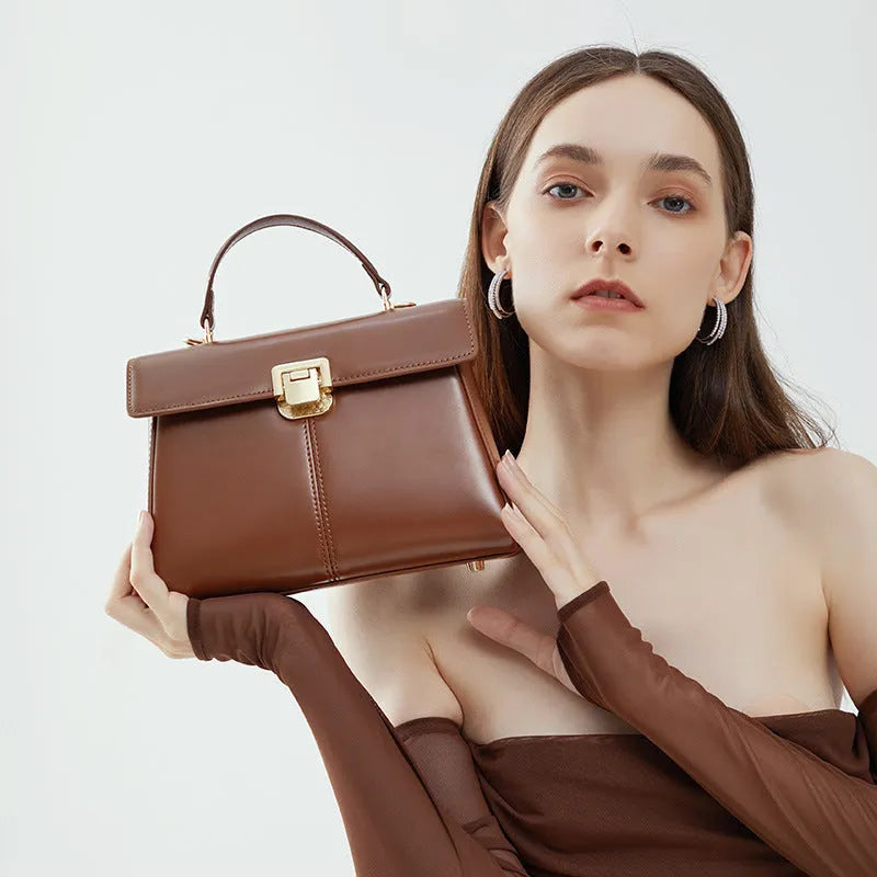 Dark brown genuine leather women's shoulder bag with a clasp, showing its horizontal square shape and shoulder strap.