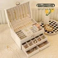 Leather jewellery box with three drawers open, showing storage for necklaces, earrings and bracelets.