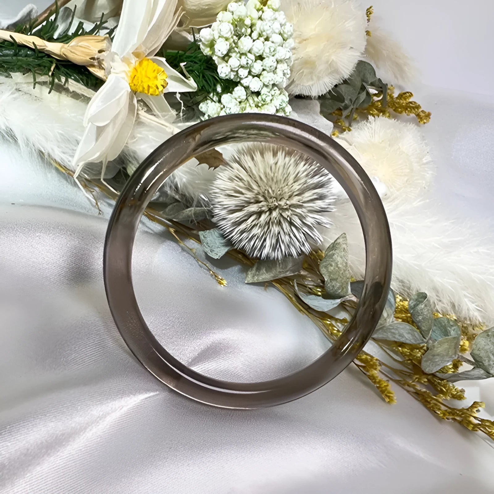 Natural obsidian bracelet with polished finish in round bar jingle style on white background