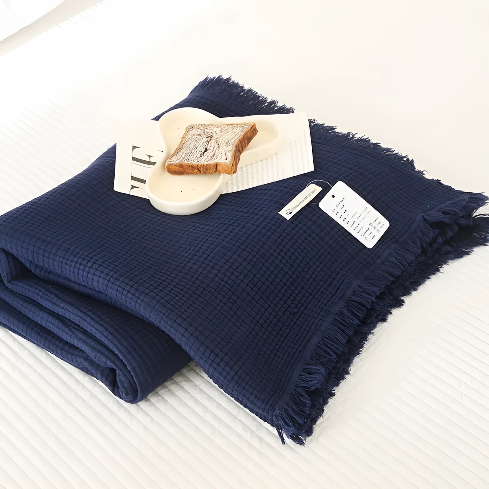 Four-layer gauze cotton blanket with tassel trim in avocado green, laid flat.