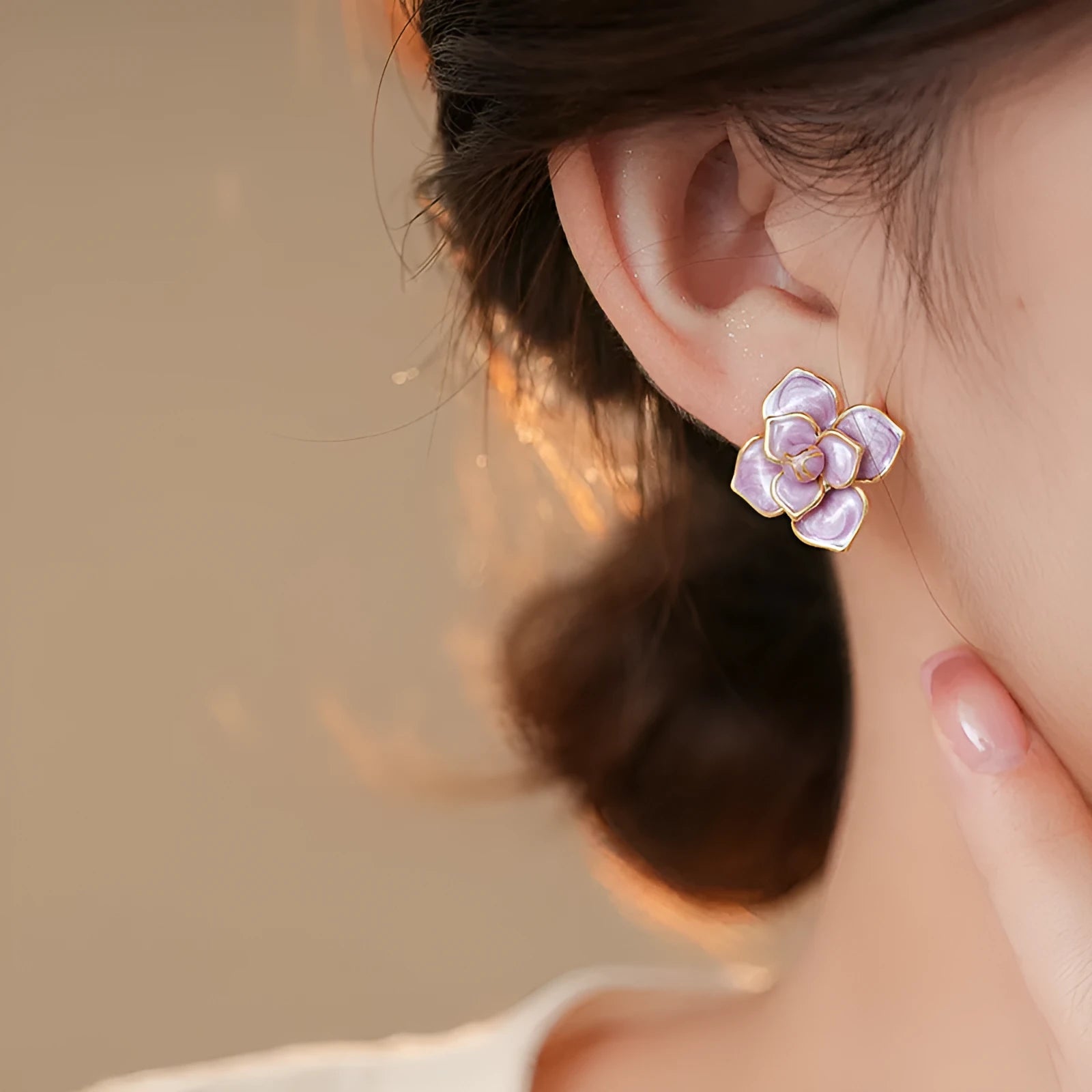 Gold plated purple oil-spot glaze flower stud earrings on a white background, showing detailed petal design and matte finish.