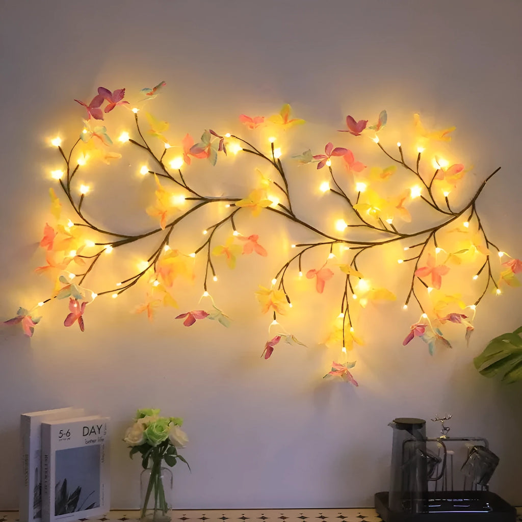 Tall flexible LED rattan tree lamp with colour-changing butterfly decorations lit up.