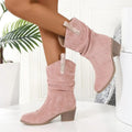 Mid-calf suede boots with a block heel on a neutral background, showing leather stitching detail and round toe.