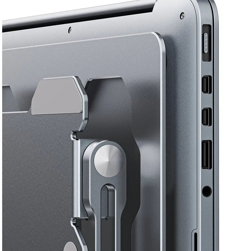 Grey aluminium laptop stand with adjustable angle, folded flat next to a laptop.