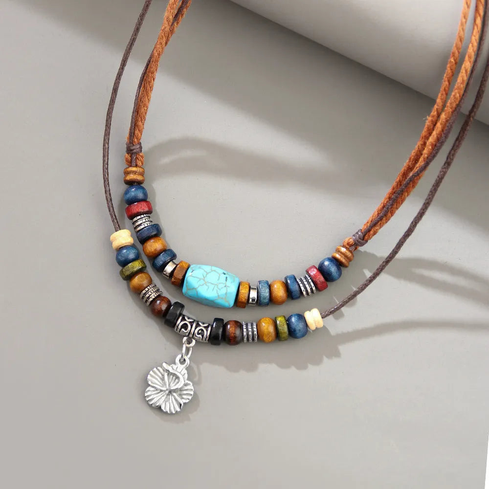 Turquoise wooden bead necklace with alloy geometric flower pendant on brown wax rope cord