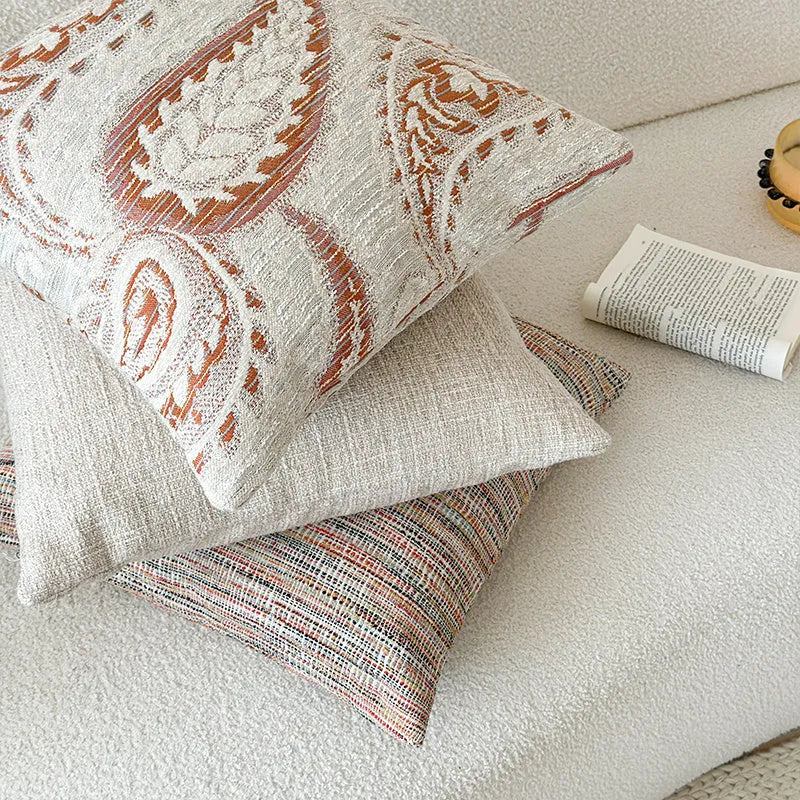 American-style jacquard paisley pattern sofa cushion cover in an amber colour on a grey sofa.