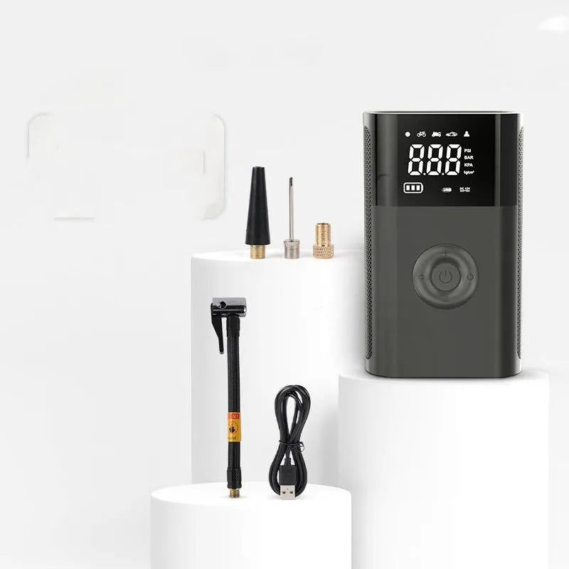 Black handheld wireless digital tyre inflator with LCD screen, showing pressure reading, with accessory nozzles
