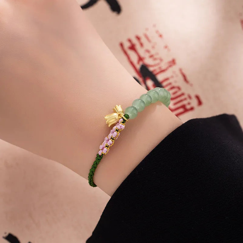 Red rope hand woven women's bracelet with floral elements in national style