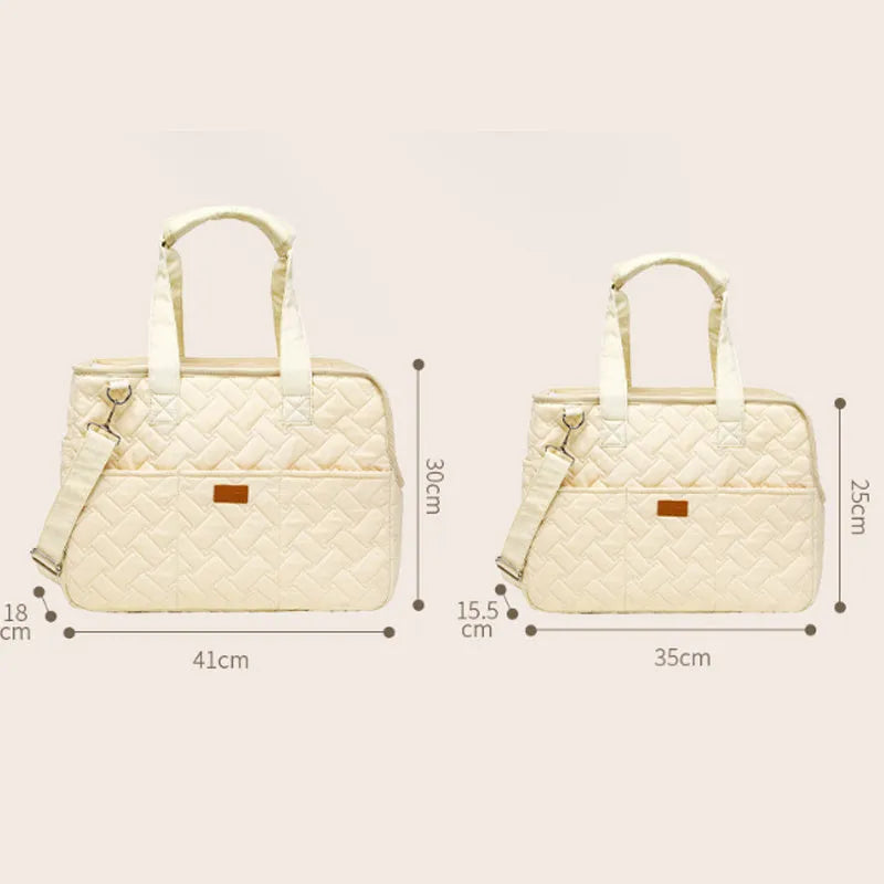 Grey pet carrier handbag with mesh panels and multiple pockets, shown with a small dog inside.