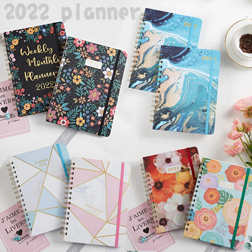 A5 spiral notebook with colourful floral cover, open to show lined pages and metal coil binding