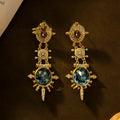 A pair of gold geometric retro-style alloy stud earrings with round diamond-treatment details.