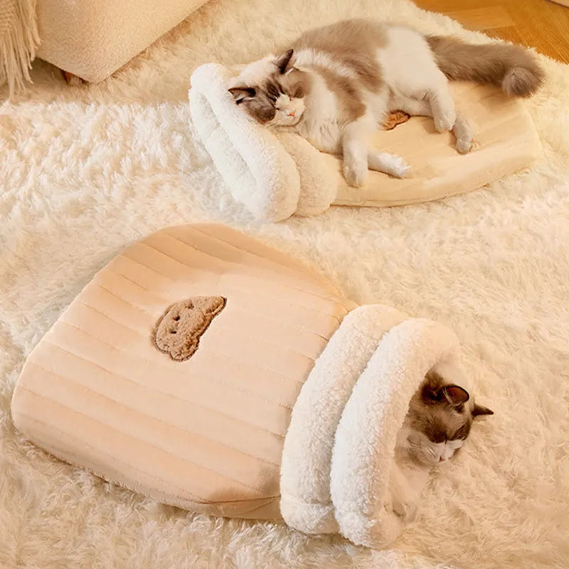 Fleece cat sleeping bag nest in light brown colour with a 3D entrance, shown on a wooden floor.