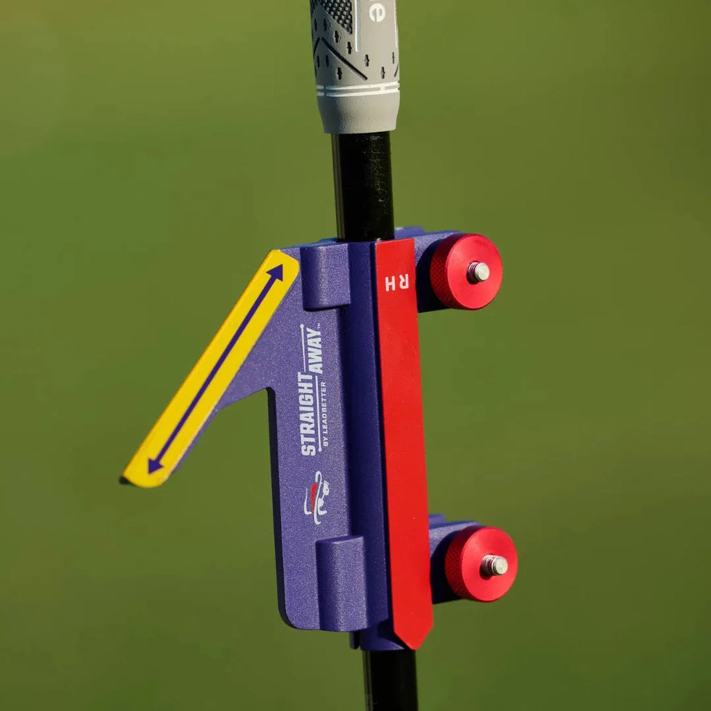 Plastic golf swing plane simulator training aid on a green background.