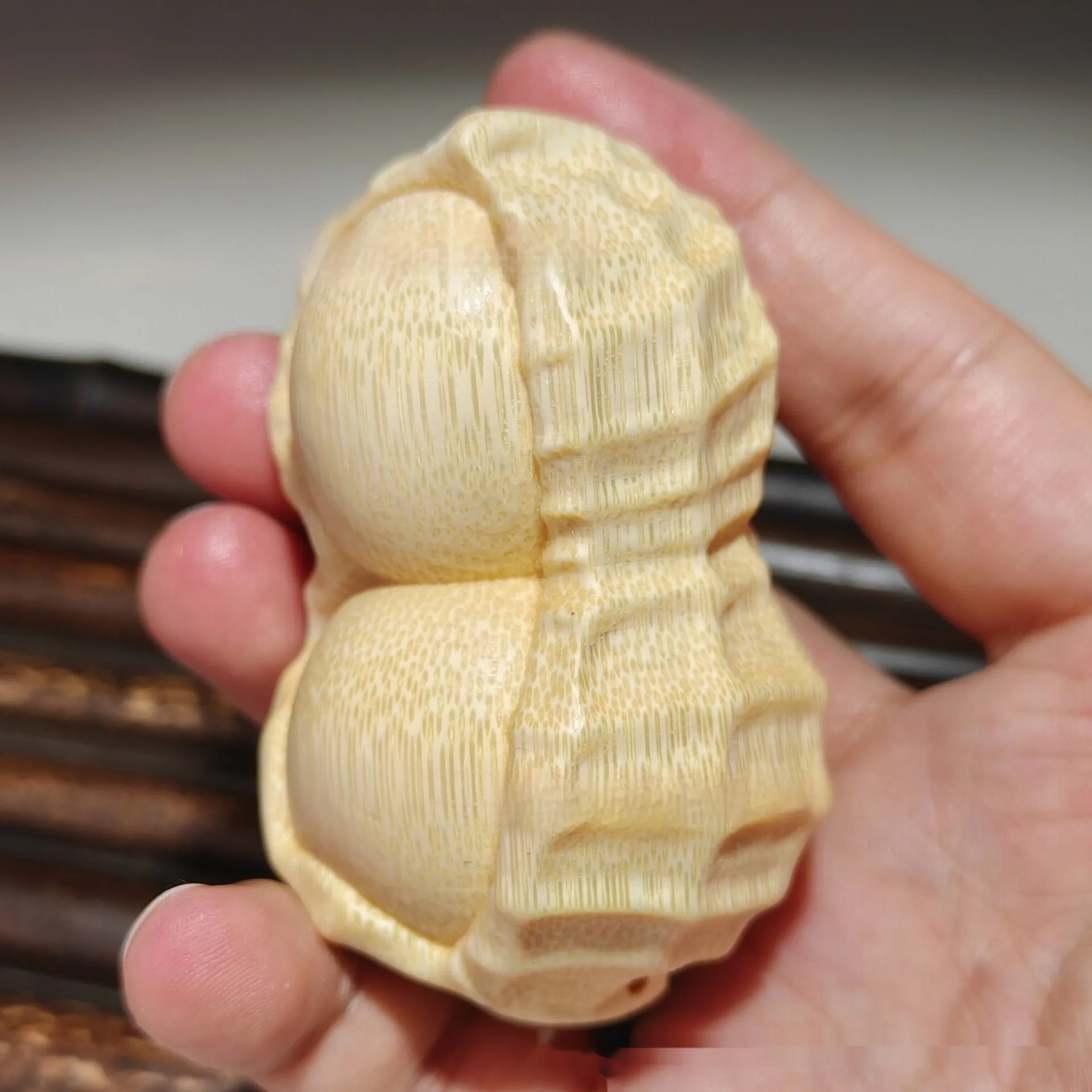 Solid natural bamboo peanut ornament with engraved message on wooden surface