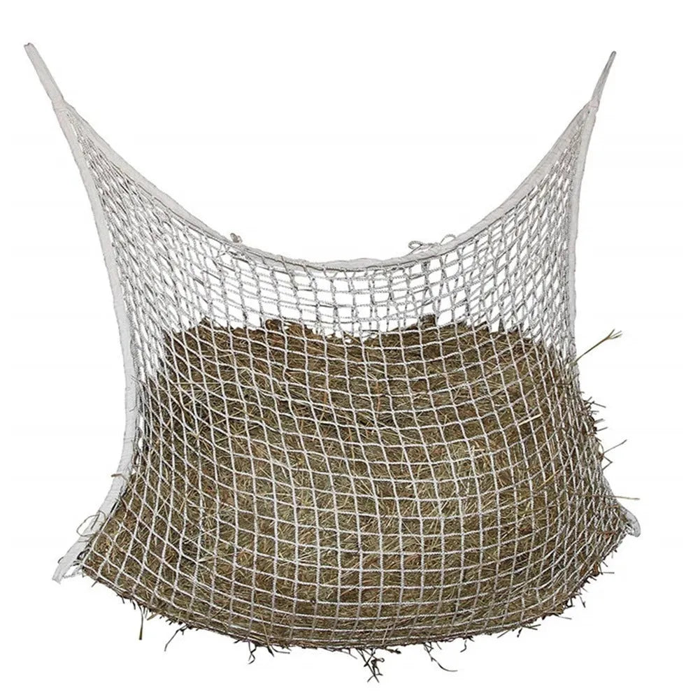 Black woven grid horse feeding bag hanging, filled with hay.
