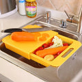Blue kitchen chopping board with built-in sink drain basket and TPE handle on a counter.