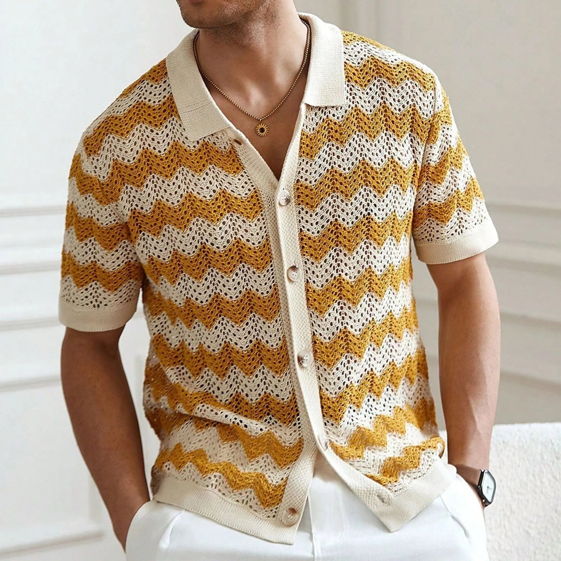 Man wearing a blue short-sleeve sweater with a textured hollow jacquard corrugated pattern and flocked detail.