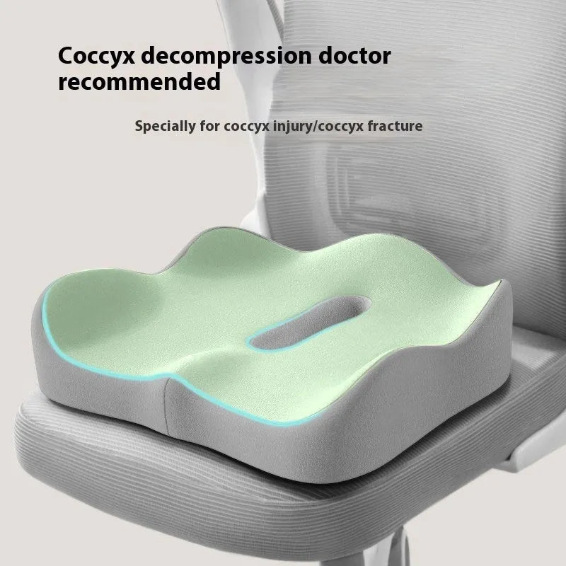 A grey and blue memory foam seat cushion for waist and tailbone support on an office chair.