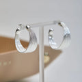 Geometric multi-layer copper earrings with silver or gold electroplated finish, available as studs or clips
