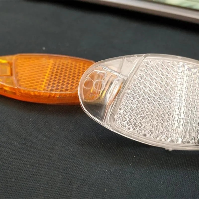 Set of 4 white and yellow plastic bicycle spoke reflectors showing 7.2cm x 3.5cm dimensions