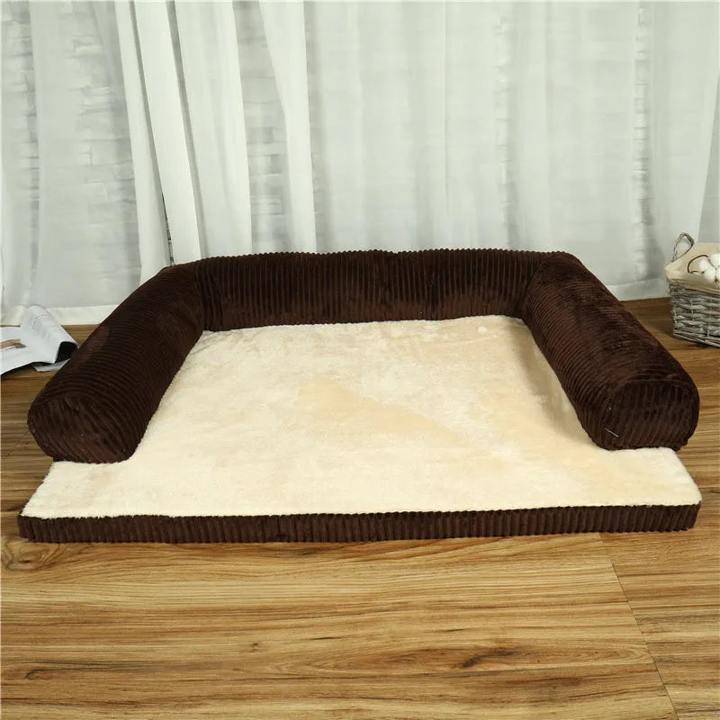 Grey corduroy pet sofa dog bed with bilateral bolsters and a non-slip cloth base on a wooden floor.