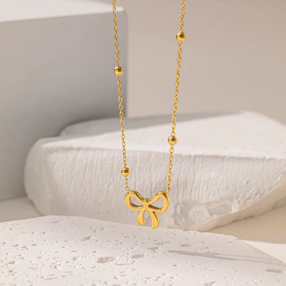 Gold electroplated titanium steel necklace with bow design and cross chain links