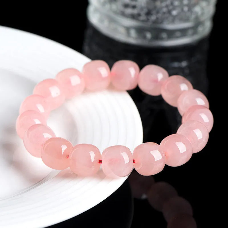 Pink natural crystal barrel bead bracelet with geometric design on wrist