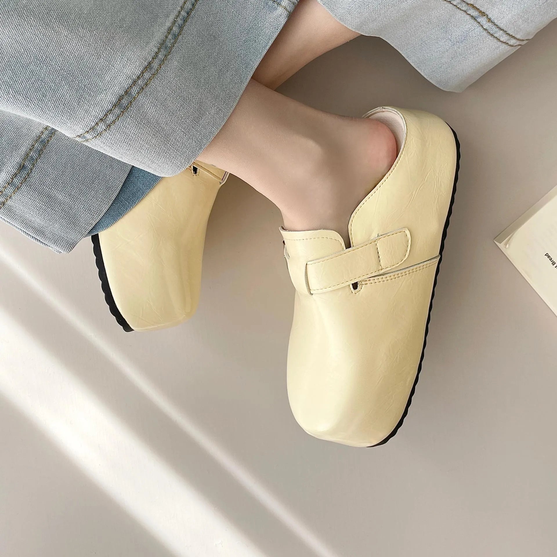 Flat buckle casual sneakers in yellow, creamy-white, silver, and black colours with round toe.