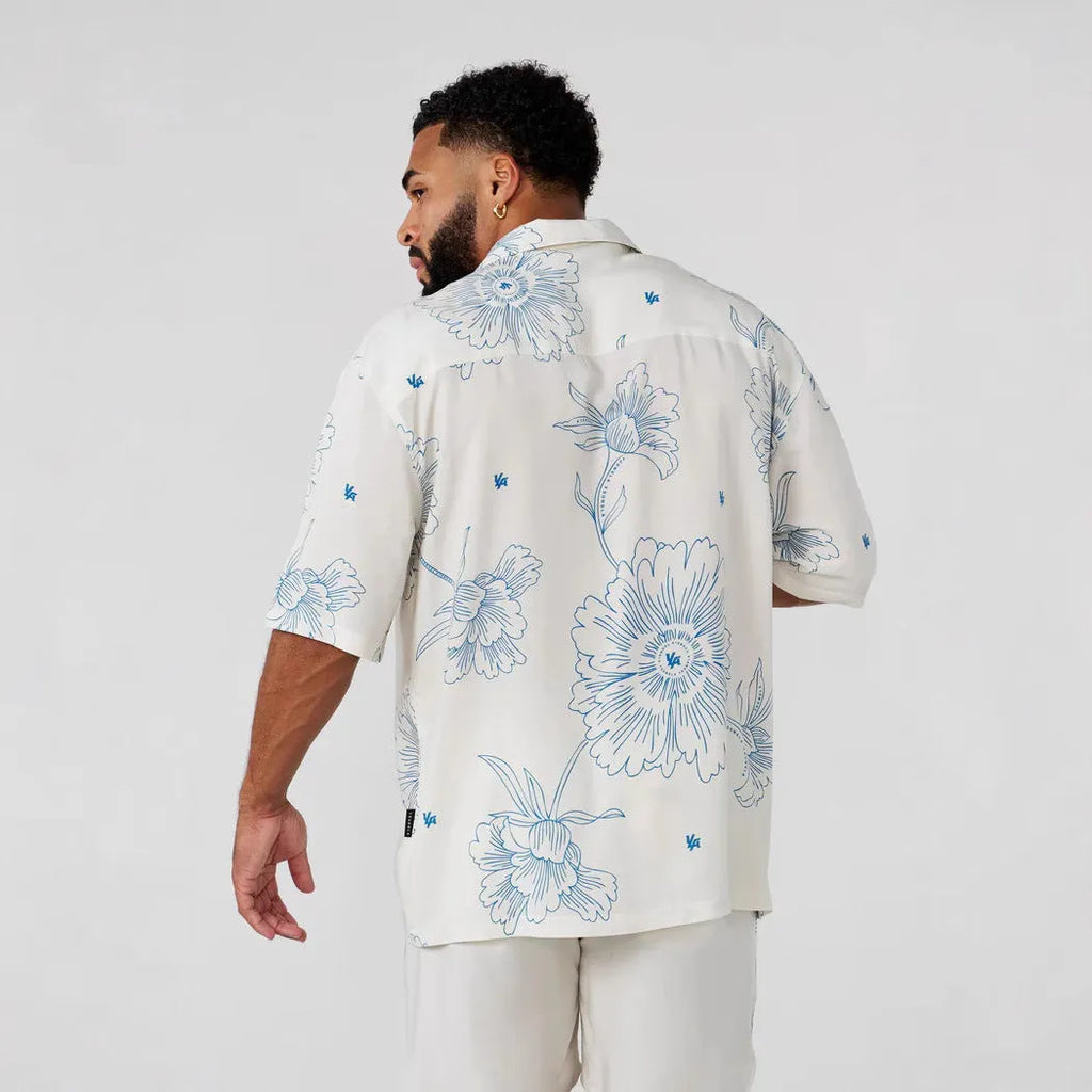 Men's loose-fit short-sleeve top with floral print in a light colour, shown on a hanger.