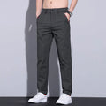 Men's straight-leg slim fit cotton trousers in light khaki colour on a hanger.