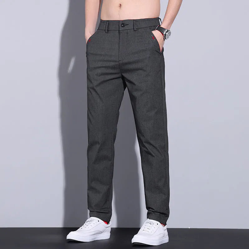 Men's straight-leg slim fit cotton trousers in light khaki colour on a hanger.