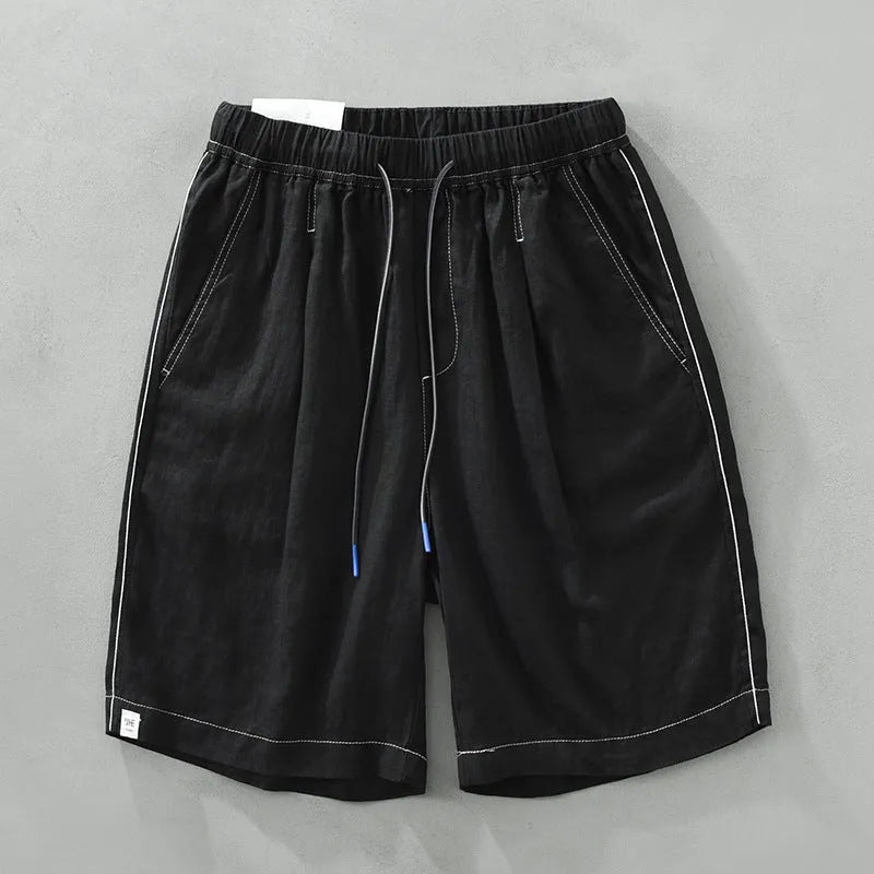Men's loose fit linen shorts in green, showing straight drooping leg and drawstring waist.