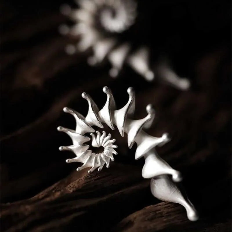 Exaggerated three-dimensional matte conch ear studs in alloy with an irregular simple style.