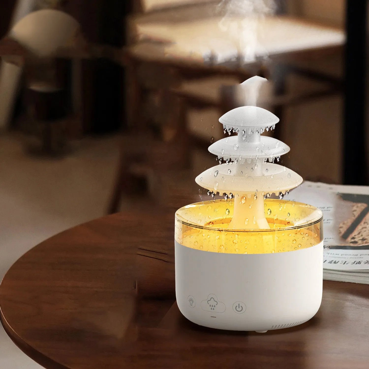 White cloud rain design ultrasonic air humidifier and essential oil diffuser with colourful LED lights on a table.