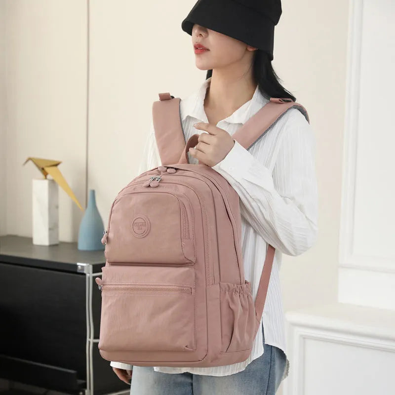 Women's waterproof nylon travel backpack with multi-compartments in rose red colour showing organisational features