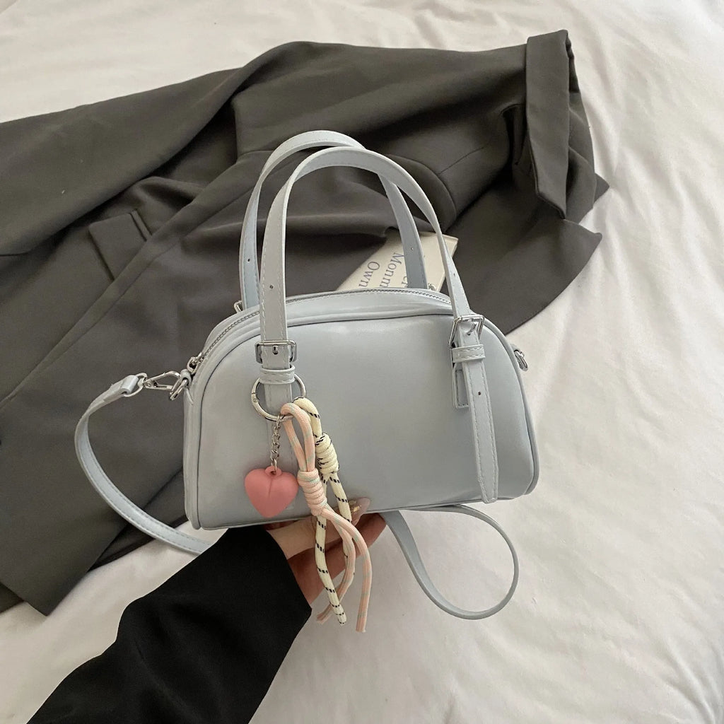 Women's square shoulder bag in PU leather with soft shell shape and optional ribbon pendant