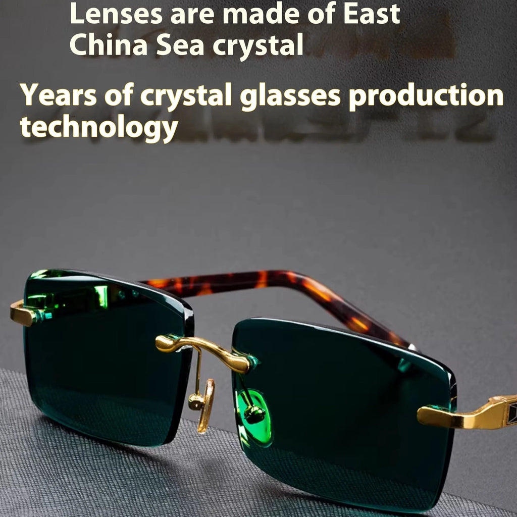 A pair of frameless sunglasses with dark green crystal lenses, shown with a hard protective case and a microfibre cleaning cloth.