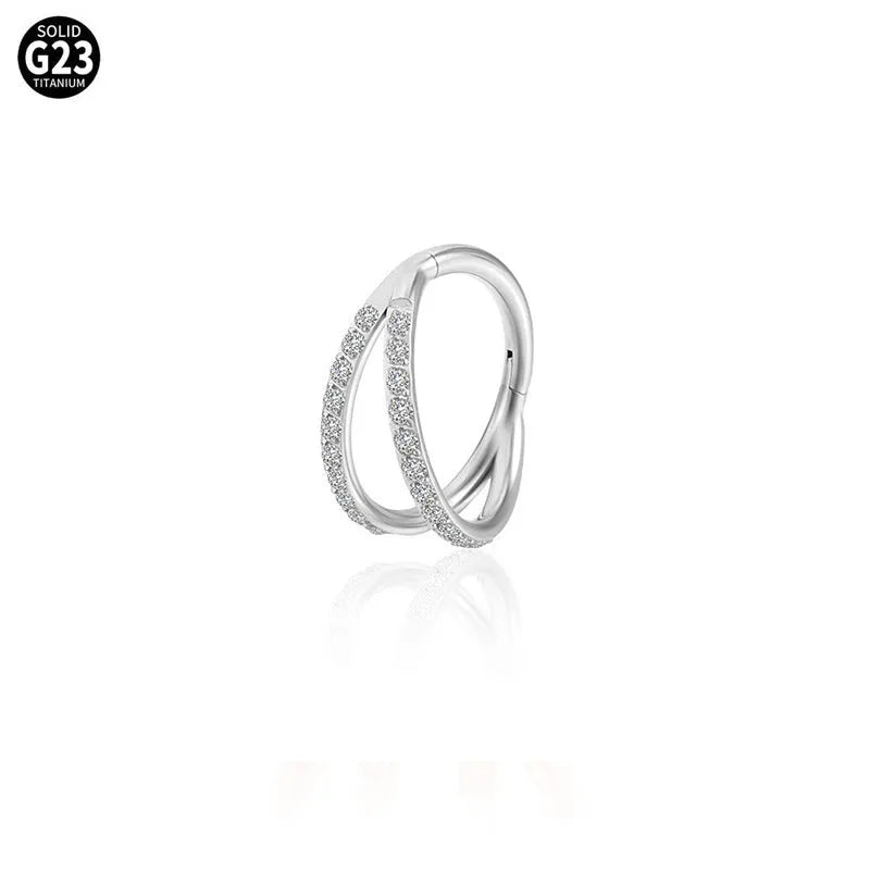 G23 titanium alloy nose ring with monoclinic diamond treatment in gold and steel colour on a grey background.