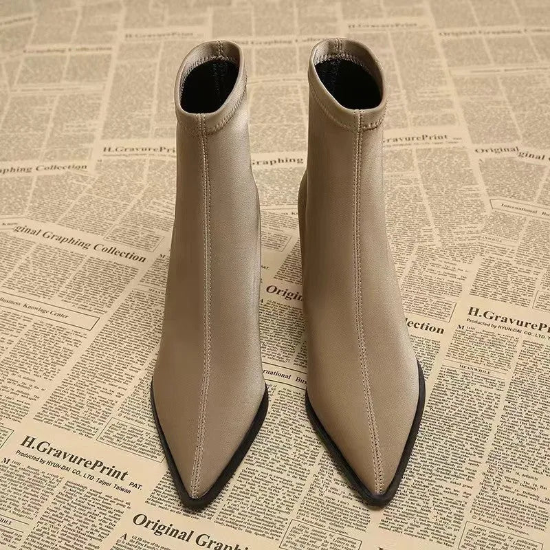 Women's khaki stretch suede pointed-toe boots with a wedge heel on a mid-calf.