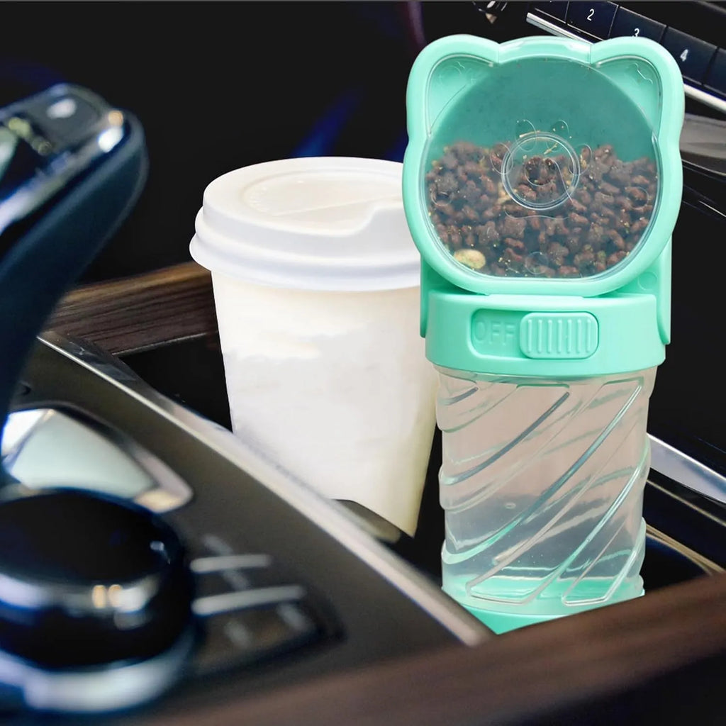 Green 3-in-1 portable pet water bottle with food container and waste bag dispenser held by hand.