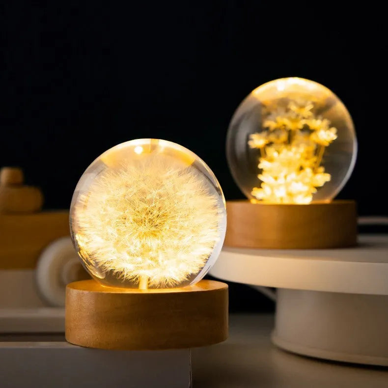 3D dandelion inside a clear resin crystal ball night light on a beech wood stand.