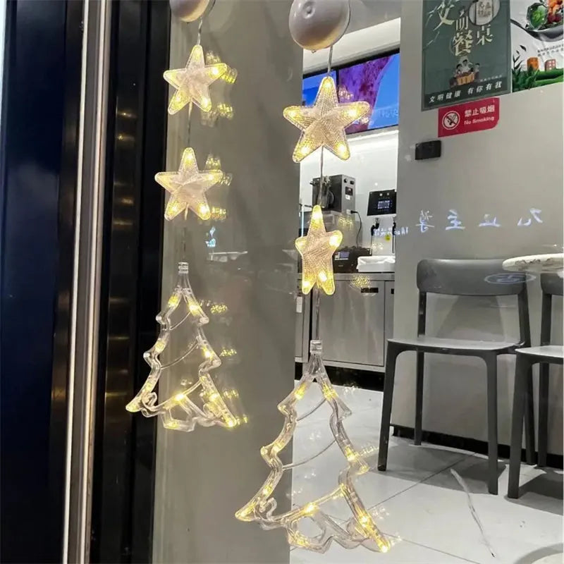 Set of three Christmas LED light pendants with suction cups, showing star, deer, and tree designs on a window.