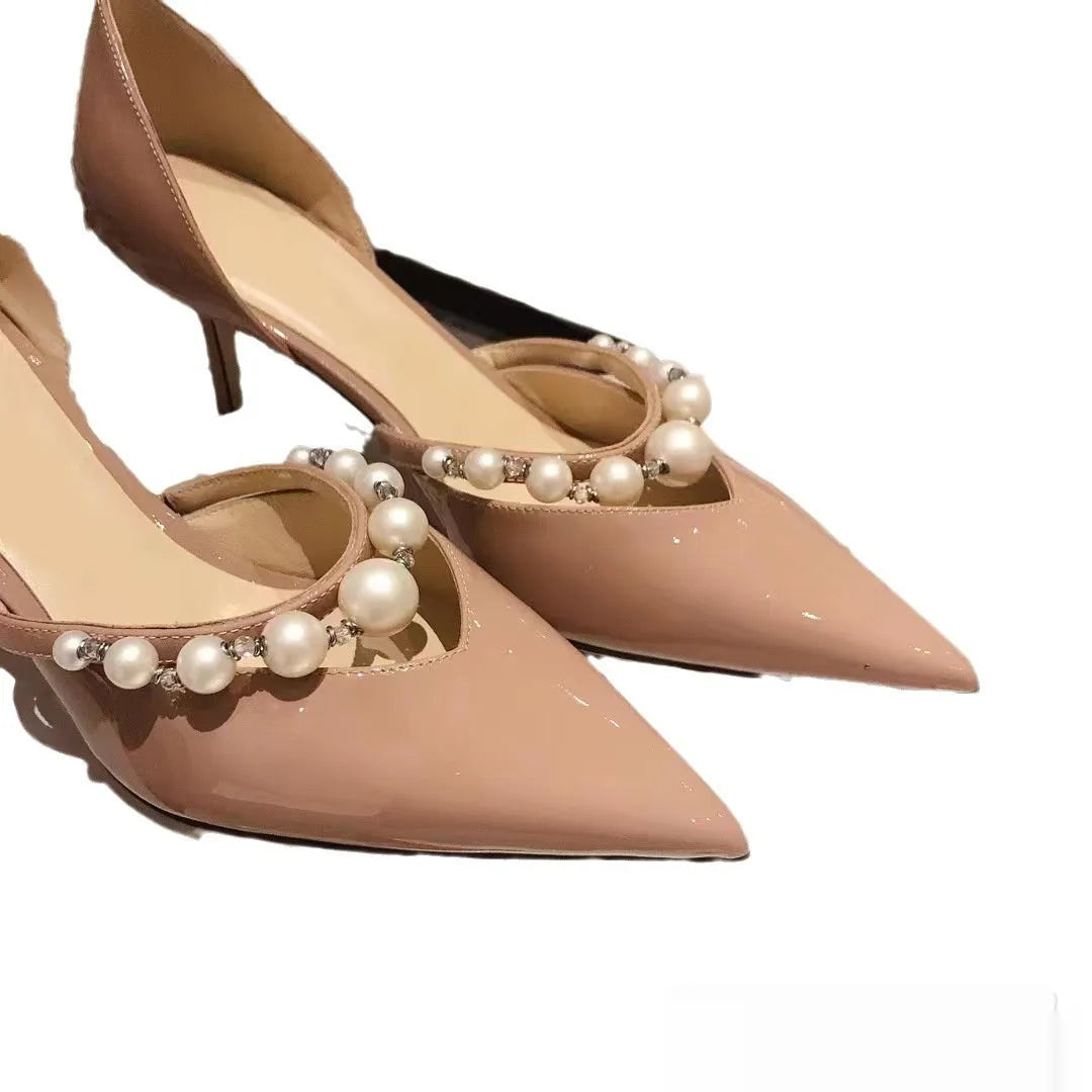 Women's nude pointed toe patent leather stiletto high heel with a pearl decoration on the side.