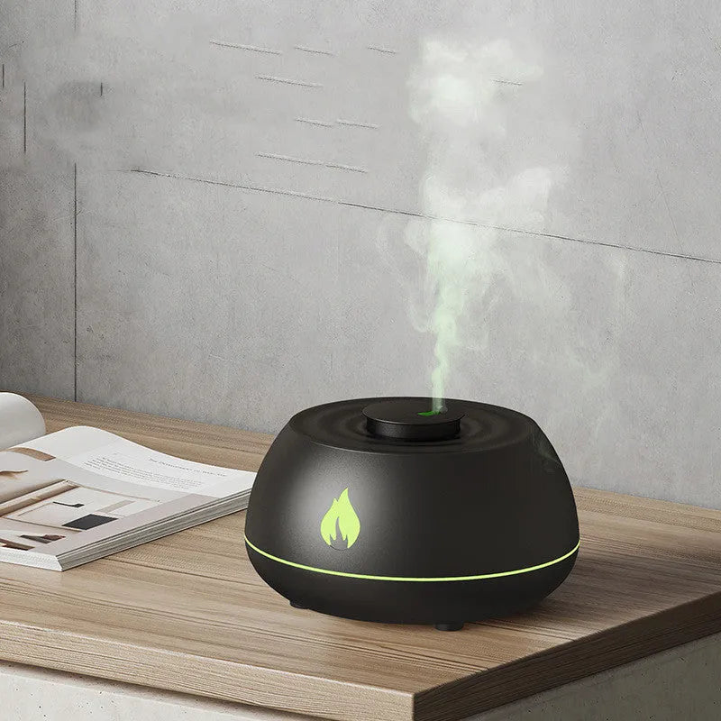 Black and white USB humidifier diffuser with glowing flame effect light on a wooden table.