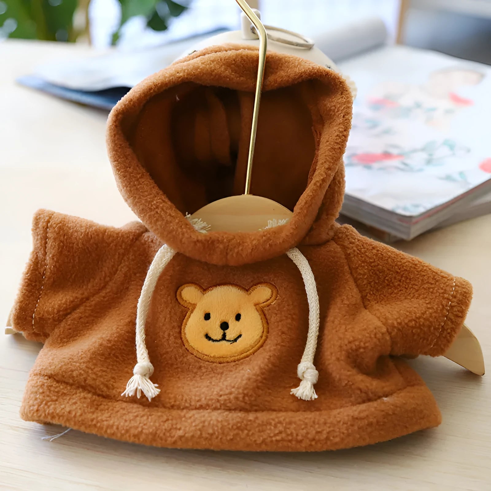 A dog wearing a soft cloth zip-up hoodie sweater in a choice of colours including a grey bear print.