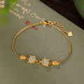 Close-up of a women's silver bracelet with a detailed fox charm and a round stone bead on an adjustable chain.