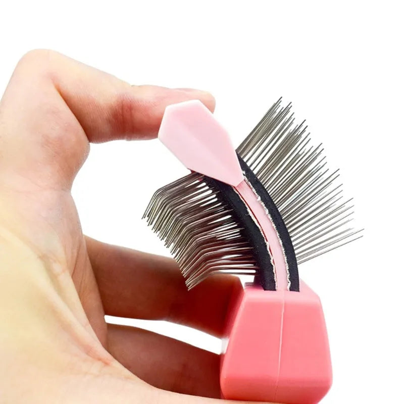 Blue dual-sided pet grooming brush with stainless steel pins on a wooden table.